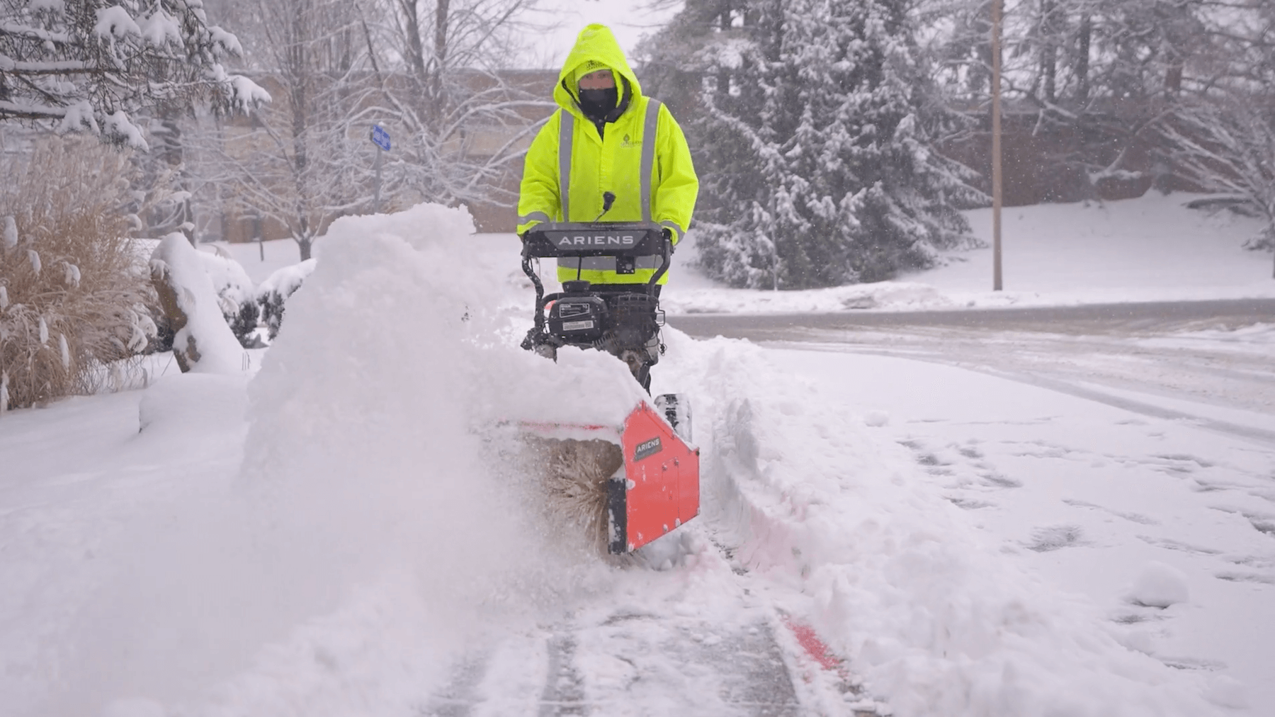 Crew Member Plowing Snow on Sidewalk