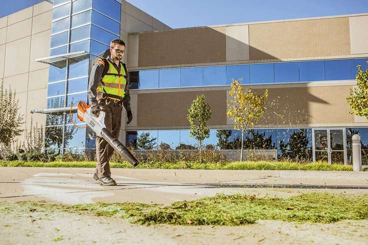 STIHL electric blower maintenance team blows grass clippings