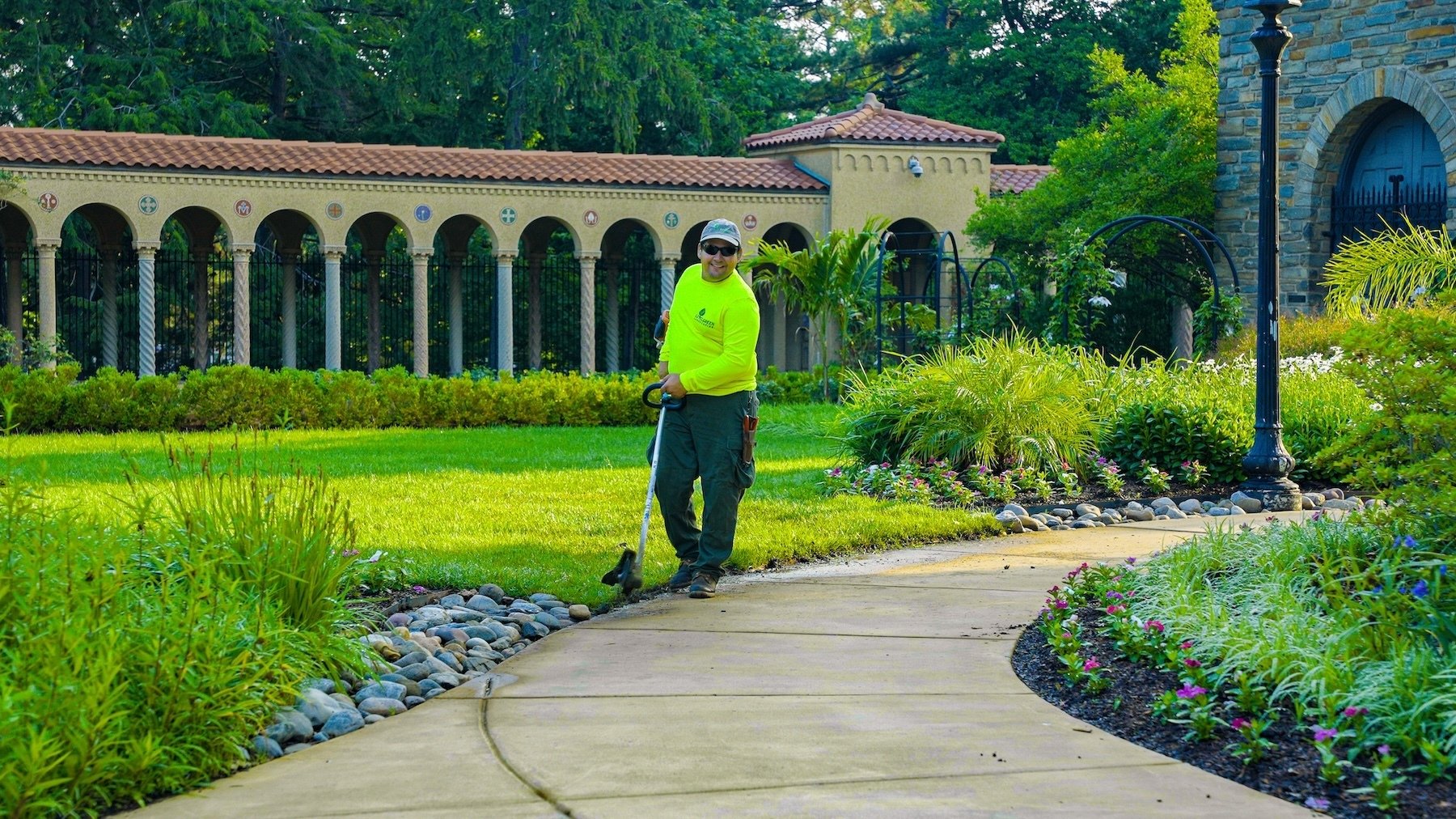 Francisan Monastery crew weed wacking along walkway