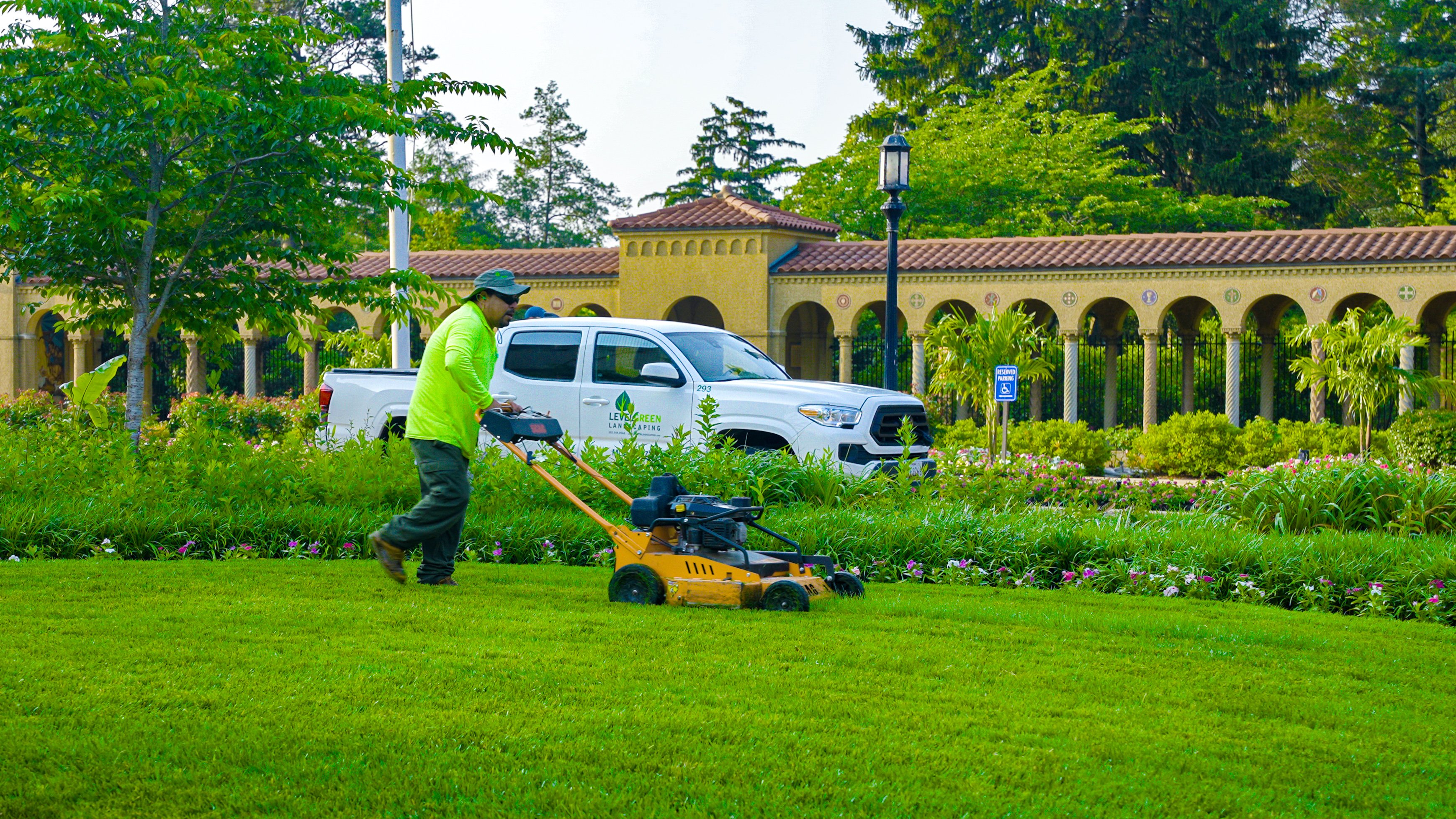Franciscan Monastery crew mowing green lawn landscape beds