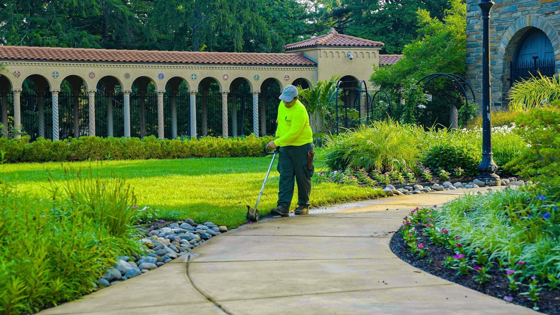 Franciscan Monastery crew weed wacking along walkway 